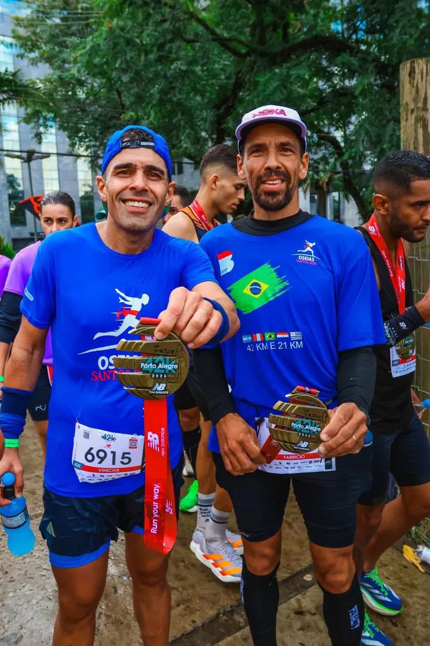 Dois atletas da equipe com as medalhas da maratona de Porto Alegre